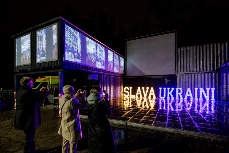 Ein beleuchtetes Gebäude mit dem Schriftzug Slava Ukraini.